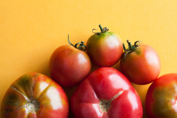 Macro view fresh ripe red tomatoes vegetables on yellow black background. Organic food concept.