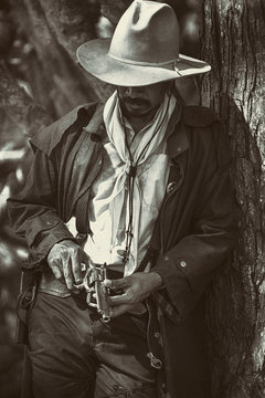 vintage photo.a cowboy stands to hold a gun