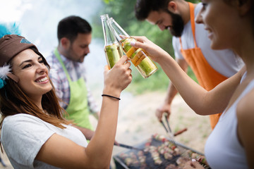 Group of happy friends having a barbecue party in nature