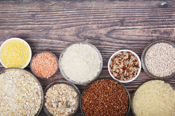 A set of bowls filled with different seeds: buckwheat, rise, corn and oatmeal	