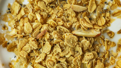 Morning food almond flakes  and milk in white bowl on wood table.