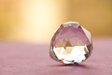 Abstract diamond stone on brown purple background. Beautiful crystal transparent gem, geometric...
