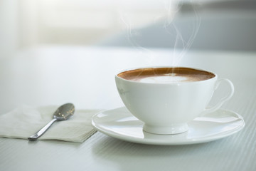 Cappuccino in a white cup on a white table