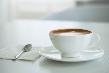 Cappuccino in a white cup on a white table