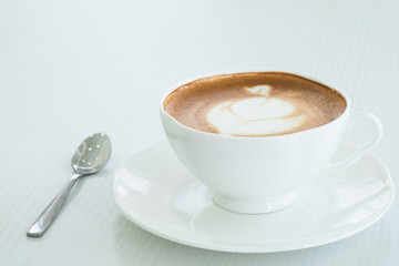 Cappuccino in a white cup on a white table