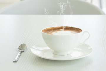 Cappuccino in a white cup on a white table