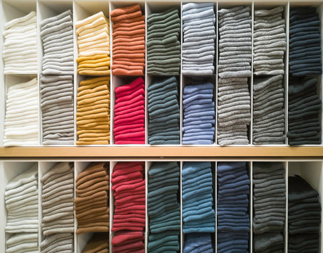 Cotton T-shirt folded neatly in the showroom,Colorful clothes folded in the cabinet,Colorful clothes neatly dressed,Shelves and multi-colored clothes in large stores,A row of colorful shirts.