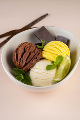Trio of tasty chocolate vanilla and lime flavored frozen dessert in a white bowl.