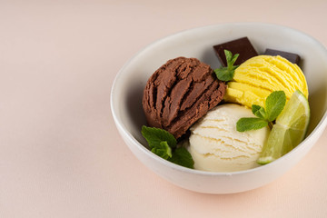 Trio of tasty chocolate vanilla and lime flavored frozen dessert in a white bowl.
