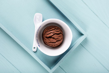 Homemade chocolate ice cream on light blue wooden background. Healthy summer food concept with copy space.