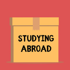 Handwriting text Studying Abroad. Conceptual photo learn outside of home in foreign country Travelling Close up front view open brown cardboard sealed box lid. Blank background