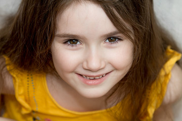 the close up portrait of little girl's face with missing front lower milk teeth in a smiling mouth