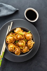 Asian dumplings in bowl, chopsticks, plates. Asian table setting. Chinese dumplings for dinner. Selective focus. Asian style decoration. Chinese fresh homemade food. Closeup