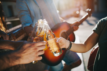 Group of friends having fun and playing guitar at summer