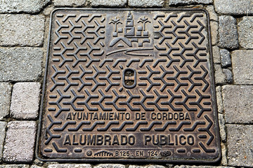 Hatch of sewage on the paving road in Cordoba, Spain. Selective focus