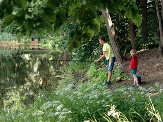 Naklejka na ściany i meble teen child catches a fishing rod on the pond.