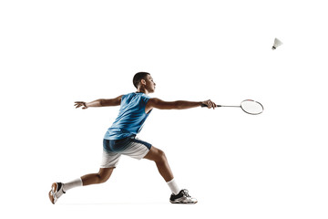 Fototapeta na wymiar Little boy playing badminton isolated on white studio background. Young male model in sportwear and sneakers with the racket in action, motion in game. Concept of sport, movement, healthy lifestyle.