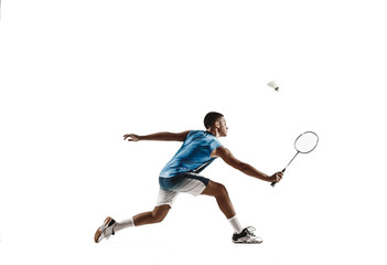 Plakat Little boy playing badminton isolated on white studio background. Young male model in sportwear and sneakers with the racket in action, motion in game. Concept of sport, movement, healthy lifestyle.