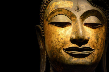 Fototapeta na wymiar clipping path, close up of antique bronze Buddha face isolated on black background, copy space (selective focus)