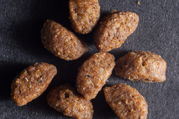 Feline dry food close-up on a dark background, macro