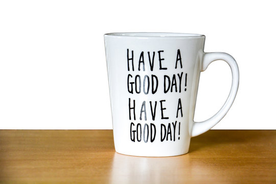 close up of white coffee or tea cup with text "HAVE A GOOD DAY!" on wooden table isolated on white background, copy space, clipping path, encouragement concept