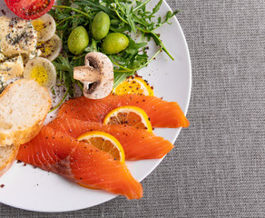 Salmon whith mushrooms, green olives, arugula and bread, salmon slices with salad and olives, trout and salad mix