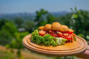 Sweet croissant with fish and chicken ,salad , vegetables . Fresh morning breakfast