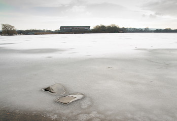 Frozen winter lake at Attenborough Nature Reserve, Nottinghamshire, UK
