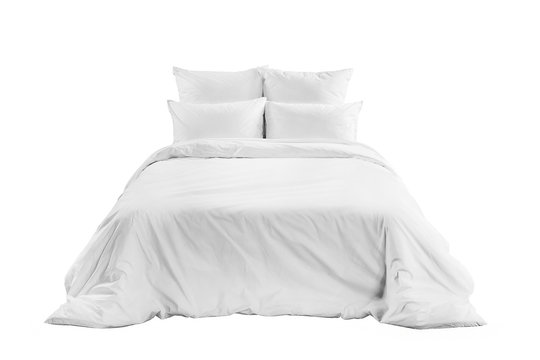 White bedlinen on a white bed isolated. Bedroom with bed and linen. Bed with pillows and duvet isolated.