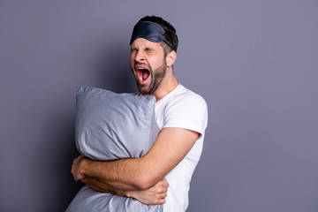 Portrait of his he nice-looking attractive exhausted sleepy bearded guy holding in hands pillow...