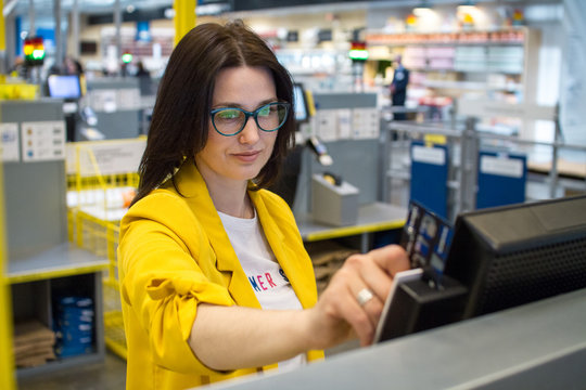 shopping, technology, consumerism and people concept. The girl in the supermarket to check their own reading of the customer card