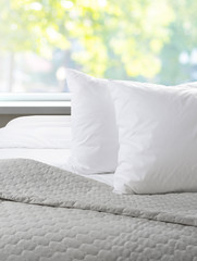 White pillows and sheet on a bed with bedspread,