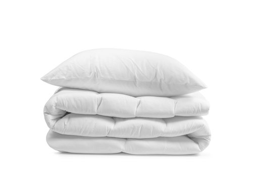 White pillow on the duvet isolated, folded beddings on the white background, bedding objects isolated against white background