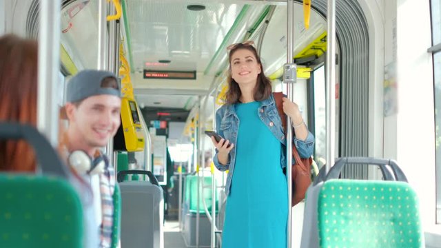 Woman paying conctactless with smartphone for the public transport in the tram