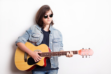 Fototapeta premium Portrait of a teenager with guitar in studio.