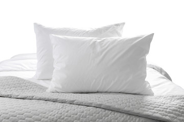 White pillows and sheet on a bed with bedspread isolated on white background