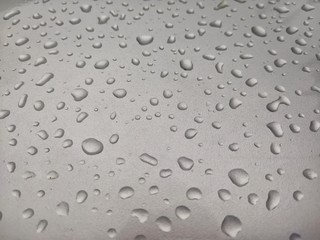 Rain water on a silver car skirt 
