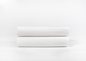 Stack of white towels or spa sheets against white backdrop