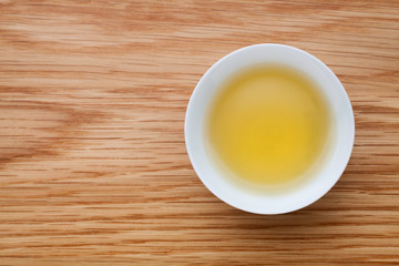 A cup of green tea on wooden table. Top view.