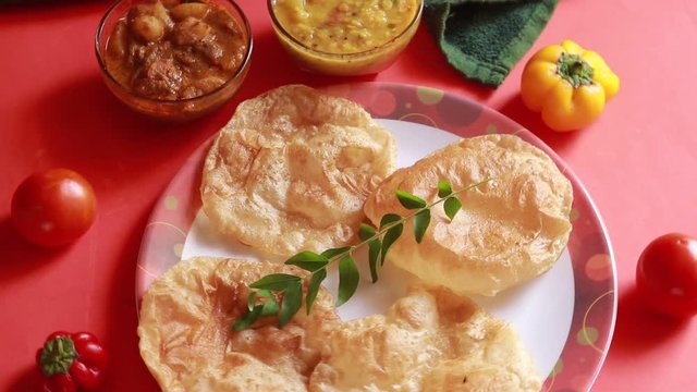 rotation Chole Bhature or Chick pea curry and Fried Puri served in terracotta crockery over  background.