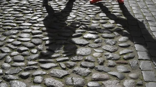shadows of people dancing on paving stone