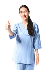 Portrait of young Asian physiotherapist showing thumb-up gesture on white background
