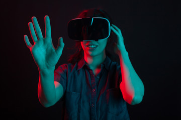 Cheerful young woman surprised while watching a movie using virtual reality headset