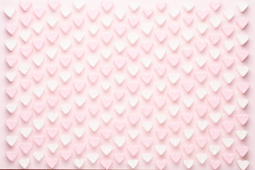 Marshmallows on pink background with copyspace. Flat lay or top view. Background or texture of colorful mini marshmallows.