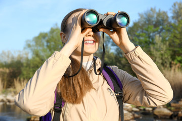 Female tourist with binocular enjoying the beauty of nature