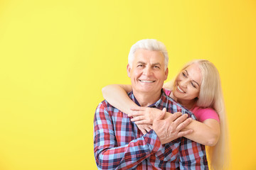 Portrait of happy mature couple on color background