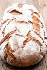 Gold rustic crusty loaves of bread and buns on wooden background. Still life captured from above top view, flat lay.