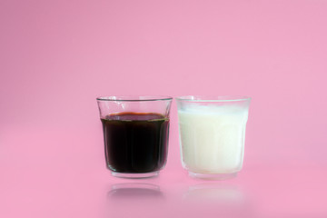 Glass of white milk, black coffee with reflection on pink background. Beverage in morning concept.