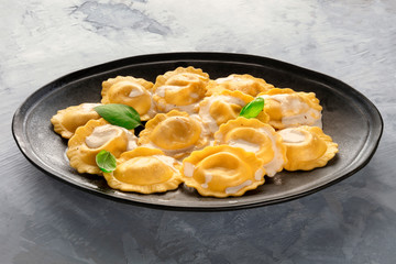 A plate of cooked Italian ravioli garnished with fresh basil leaves