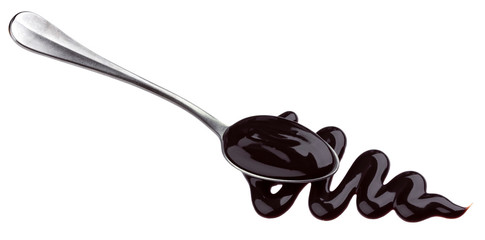 Sweet chocolate sauce in spoon isolated on white background
